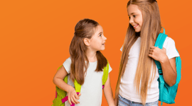 Photo of two young female students wearing backpacks