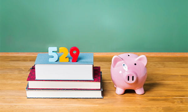 Piggy bank next to pile of books