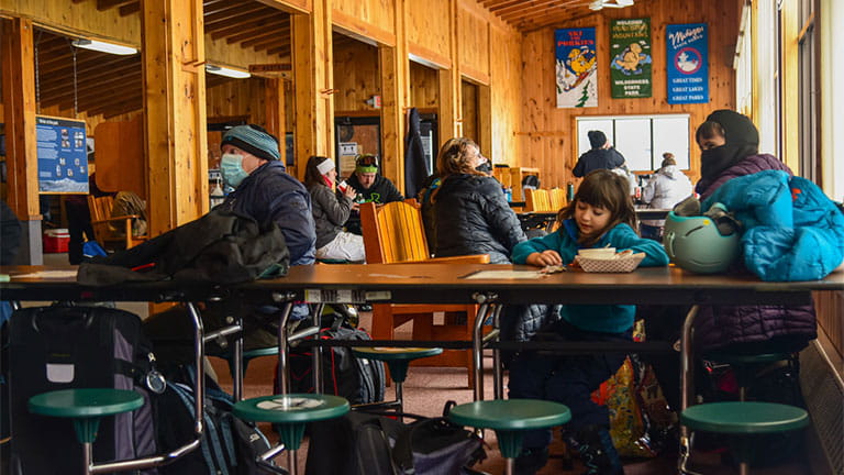 People enjoy food and beverages inside the ski lodge