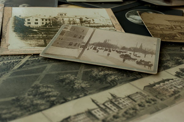 Several old black and white photos staggered on a table.