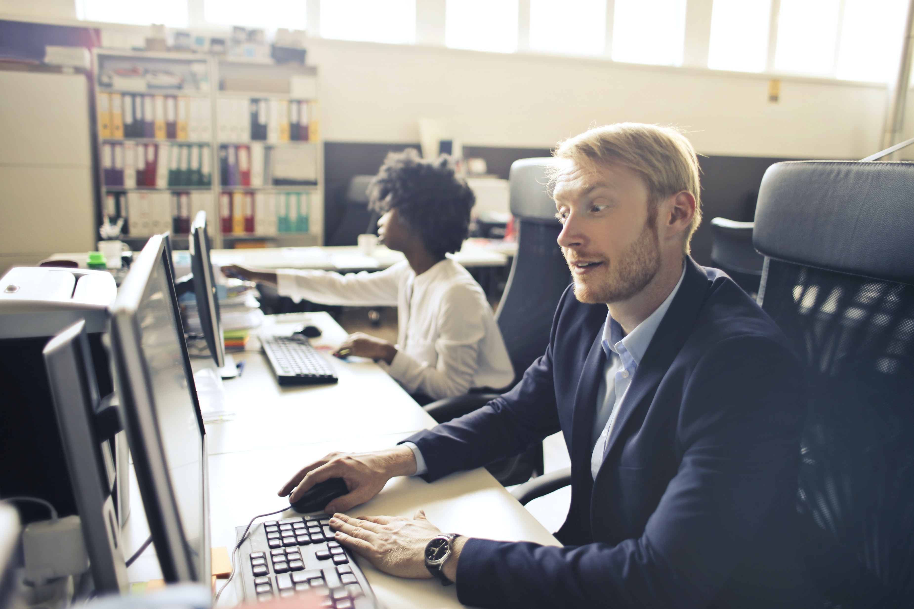 Photo of a man sitting a computer with a frustrated look on his face.