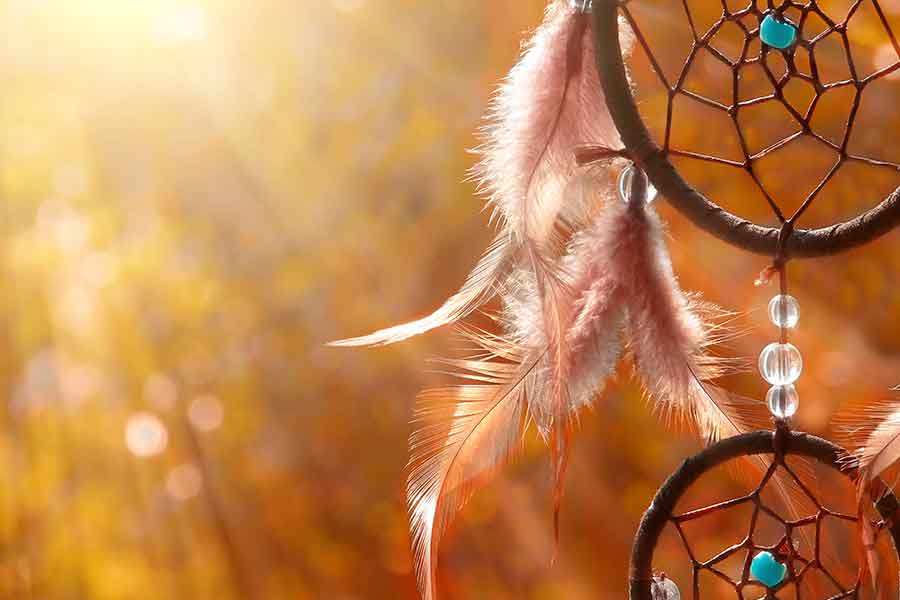 Image of a dream catcher with sunlight in the background.