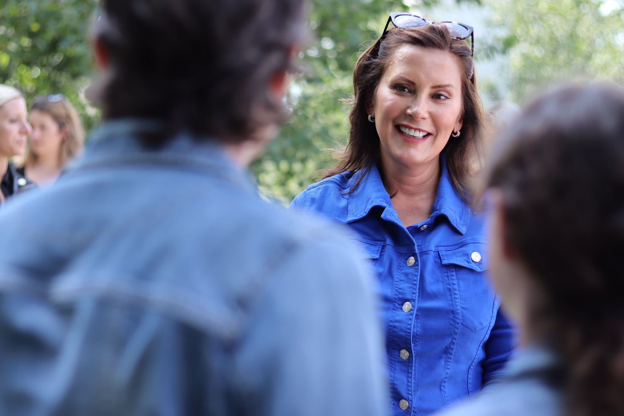 Governor Whitmer wearing a blue shirt and smiling outside with residents.