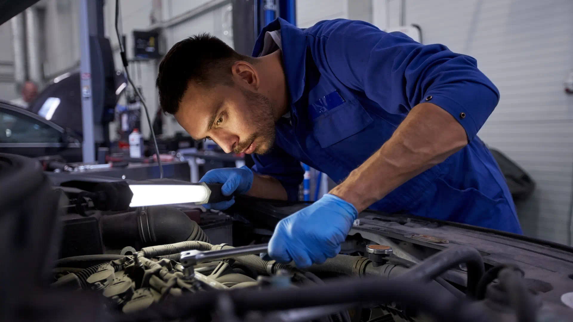 Photo of a man working on a car.