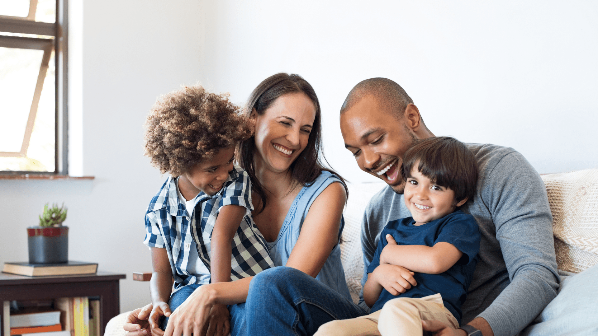 Image of a family sitting on a couch. Mother, father and two children.
