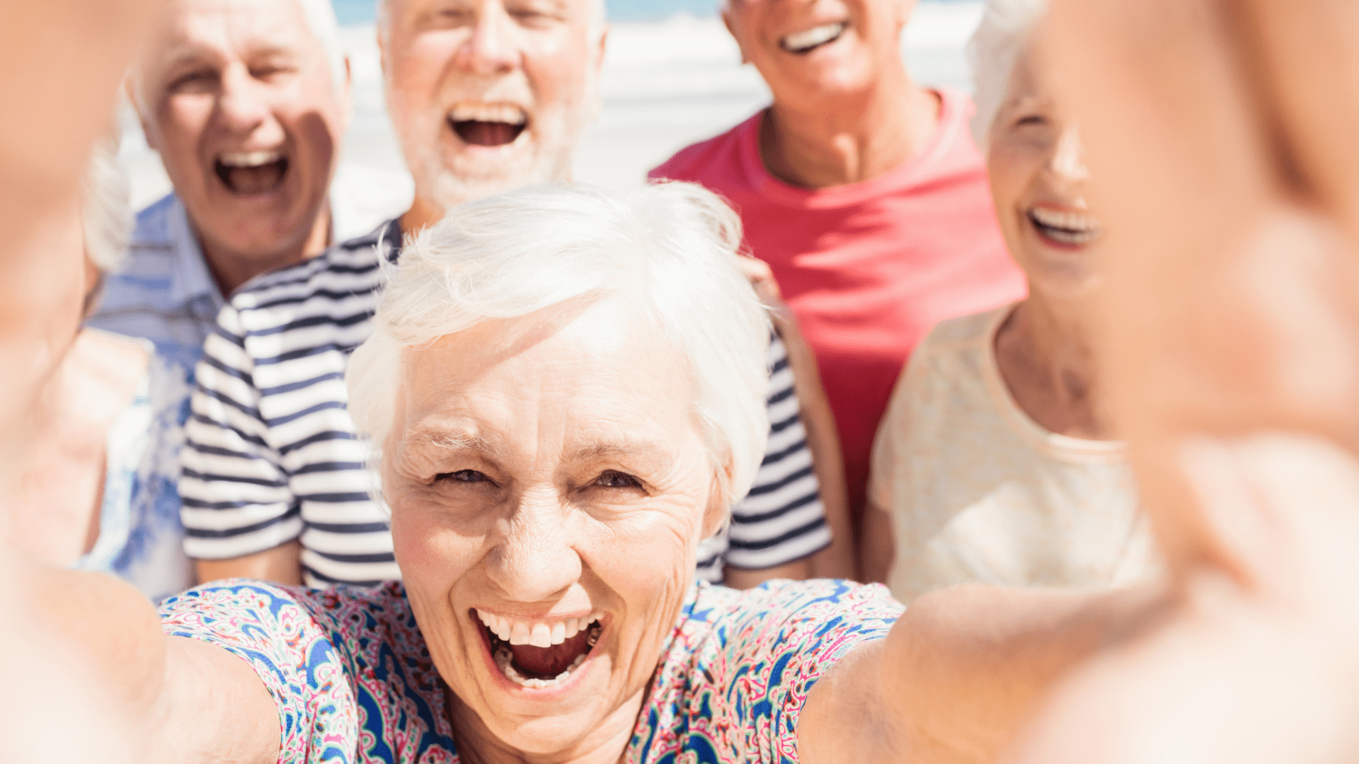 A senior woman taking a selfie in front of other seniors.