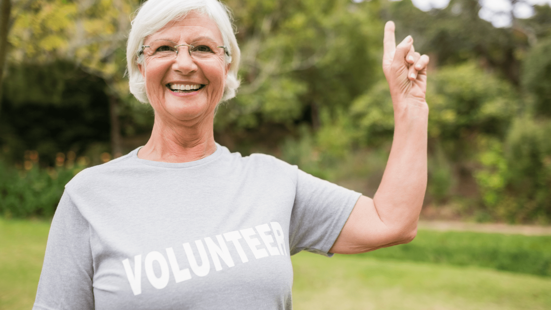 Image of a lady with the word volunteer on her shirt. She is smiling.