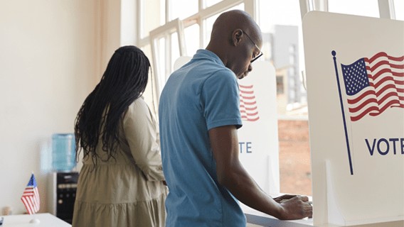 Two people voting in voting booths