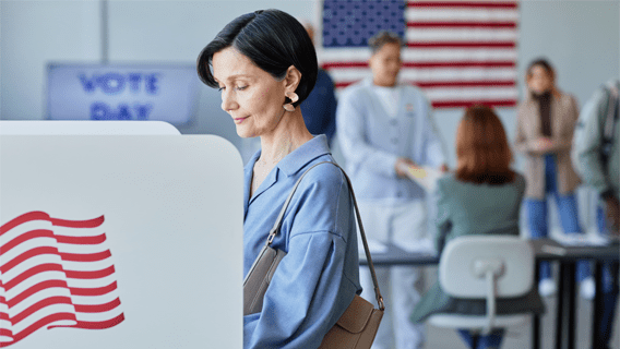 Woman standing in a voting booth on Election Day
