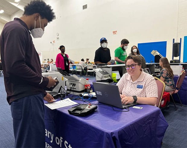 Road to Restoration Clinic April 12 2023 Lansing - female staff member helps male member of public