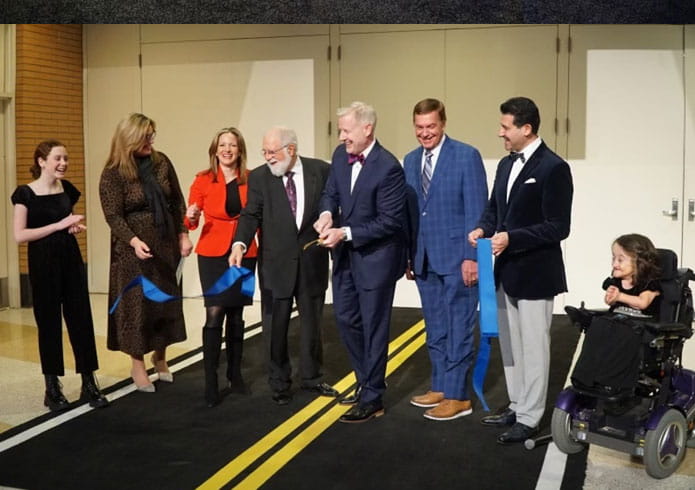 Benson assists in a ribbon cutting