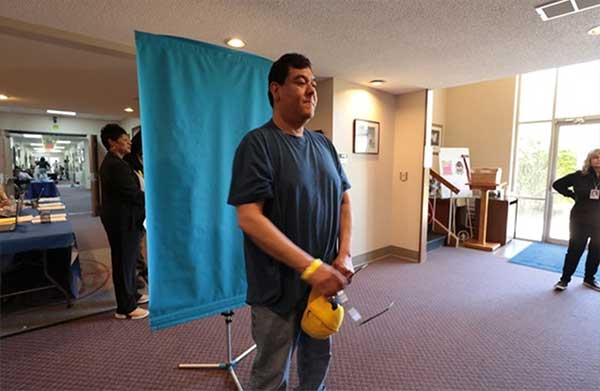 Mario Aleman of Battle Creek gets photo taken for driver's license