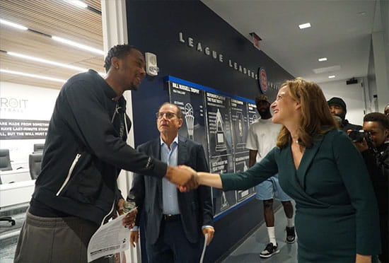 Secretary Benson with Pistons coaches, players, and employees