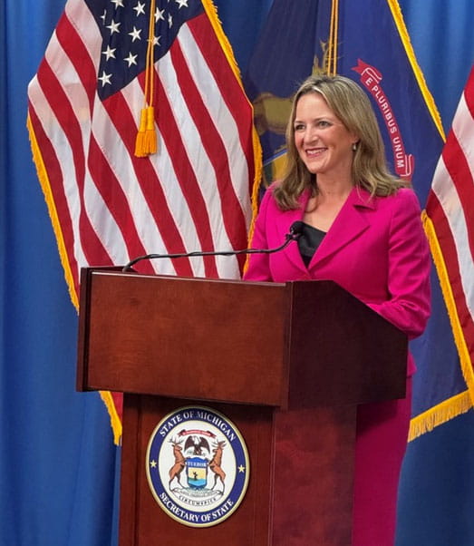 Secretary of State Jocelyn Benson speaks at the podium one week before the Primary Election
