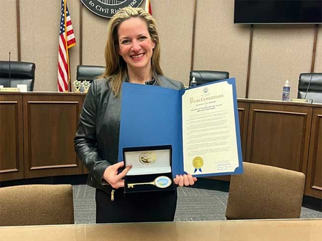 Secretary Benson holds a proclamation and key to the city