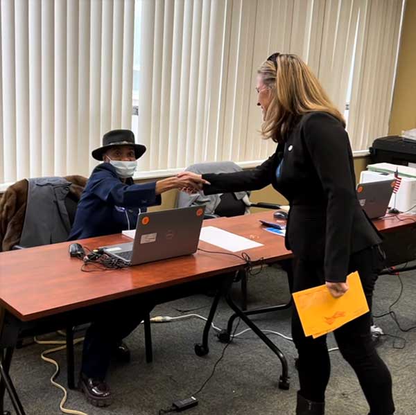 Early voting day one - An election worker greets Secretary Benson at an early voting site