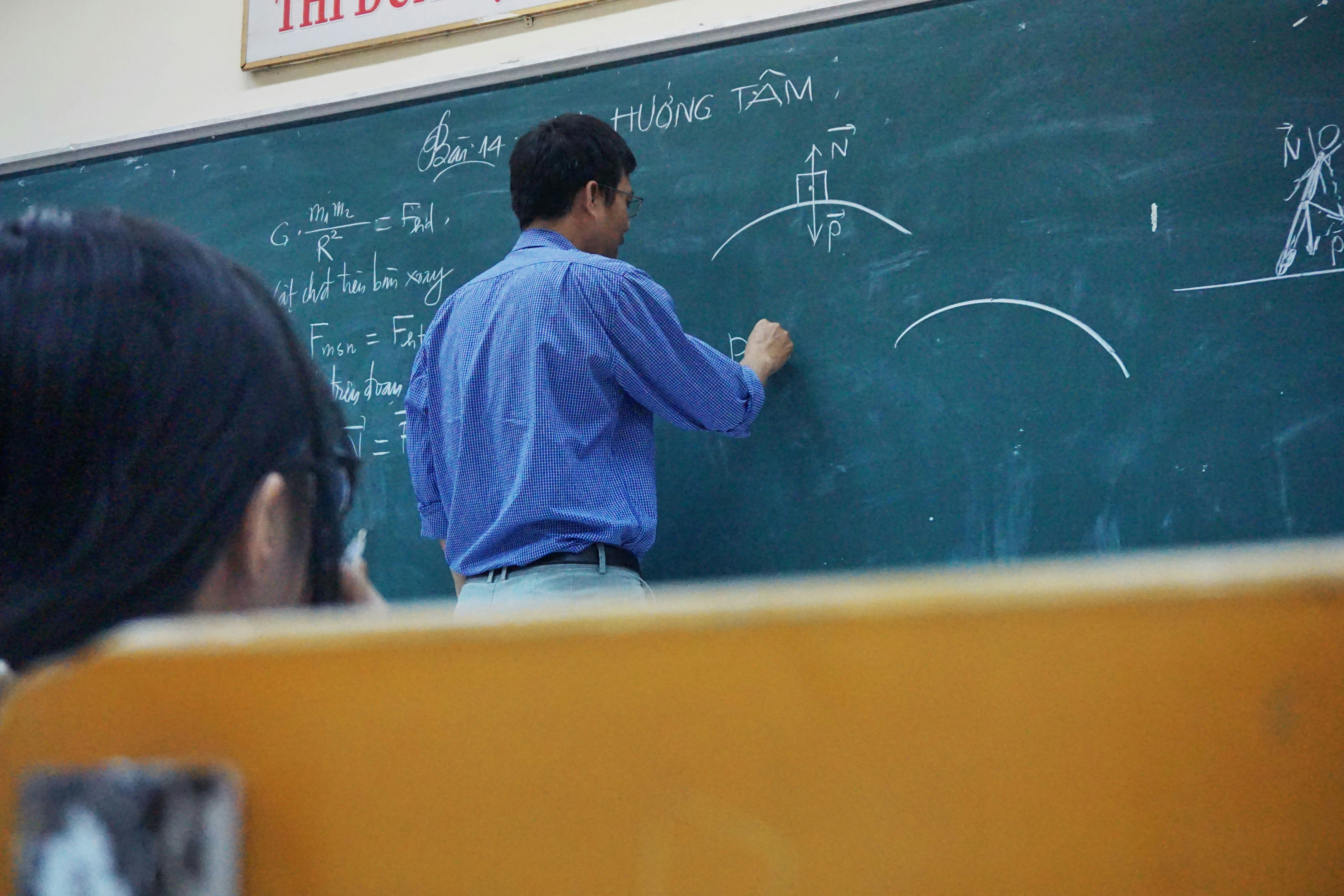 Teacher writing on blackboard