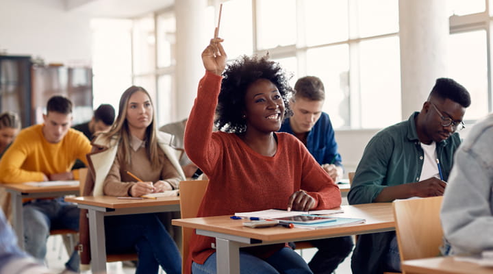 Woman in class raising her hand to ask a question