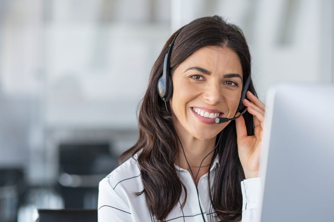 Woman wearing a telephone headset working in a call center.