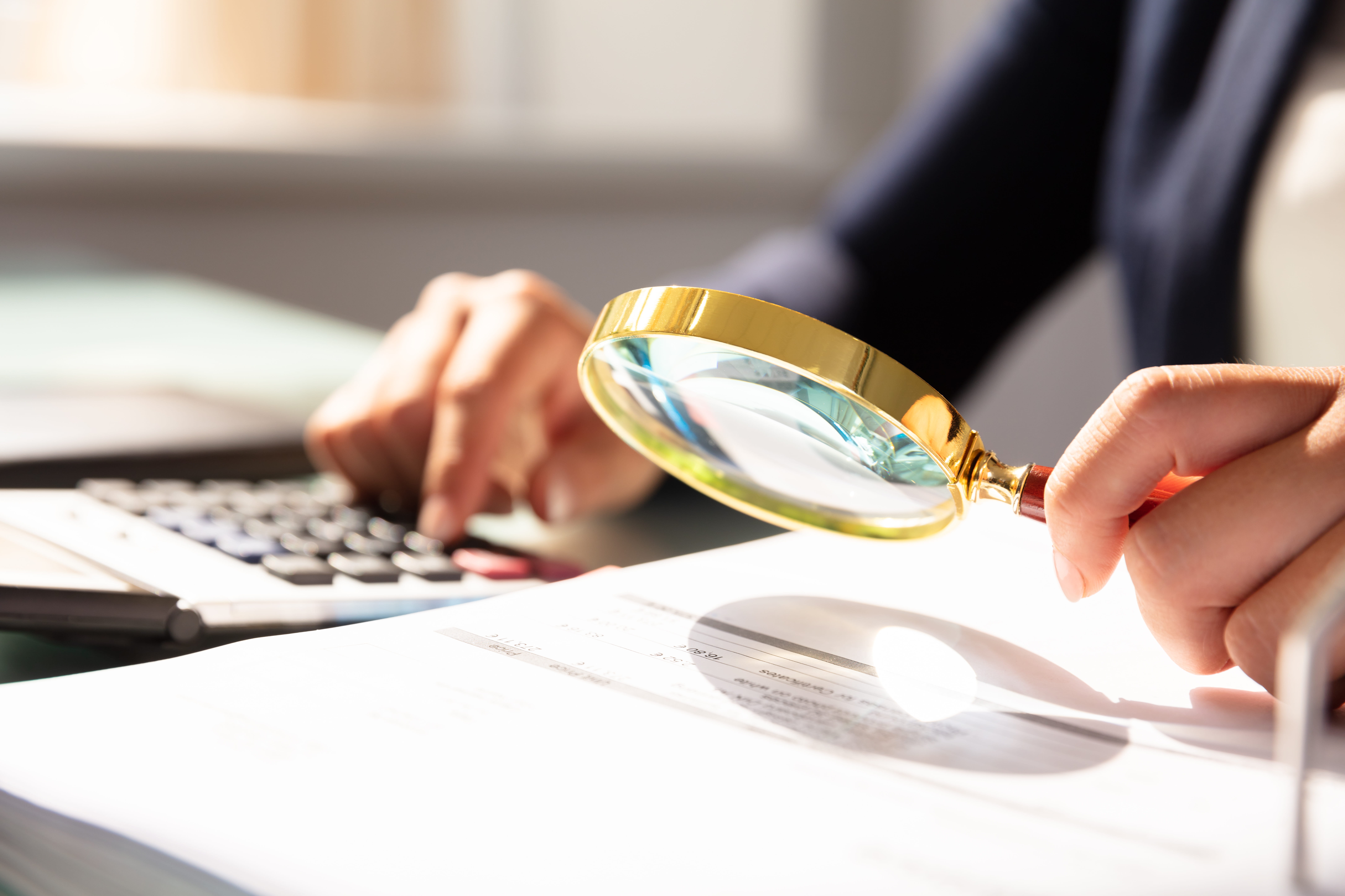 Person searching document with magnifying glass 