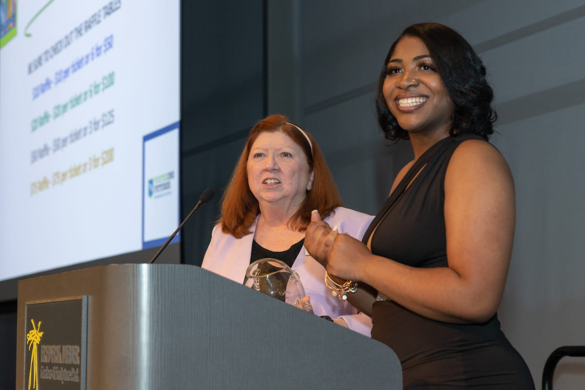 Diane Brewer (MET Program Director) and Foster Futures Spotlight Scholar Elaina Marcum draw a gold ticket winner from a fish bowl during the Fostering Futures Scholarship Trust Fund dinner.