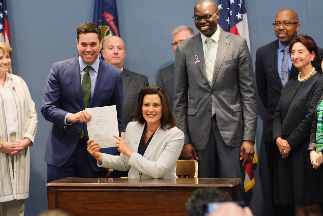 Photo of Gov. Whitmer signing an executive order.
