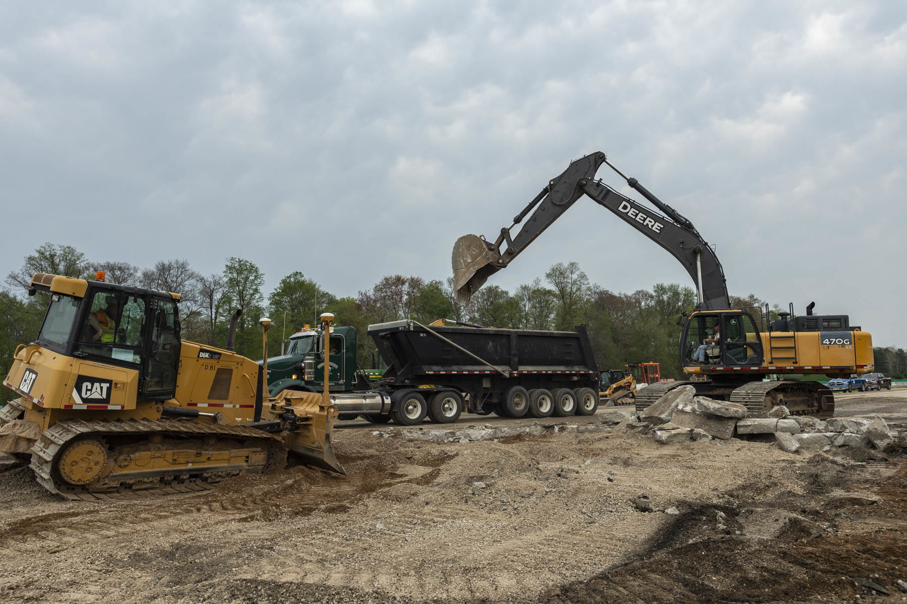 construction equipment dropping dirt in truck bed.