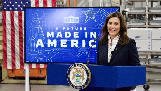 Gov. Whitmer standing in front of a podium. A screen in the background reads, A Future Made in America.